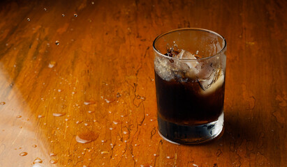 Action Shot of Ice Dropping in Cola Glass