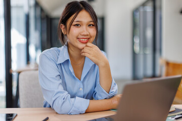 Asian Business woman using calculator and laptop for doing math finance on an office desk, tax, report, accounting, statistics, and analytical research concept
