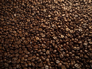 Fototapeta premium A steaming cup of coffee surrounded by scattered coffee beans.