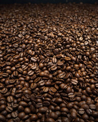 Fototapeta premium A steaming cup of coffee surrounded by scattered coffee beans.