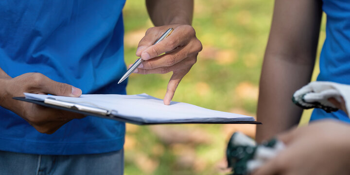 Volunteers discussing plans during a community clean-up event, promoting sustainability and teamwork.