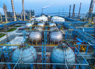 Industrial plant with spherical tanks and sea bridge background