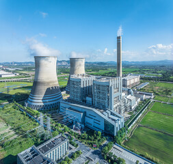 Aerial view of power station and cooling towers on sunny day