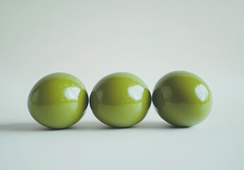 Three shiny green spheres in a row on a white background.