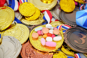 Different pills on many medals background. Doping in sport concept.	