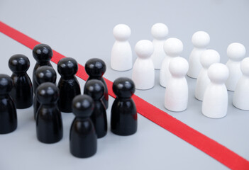 Two groups of white and black people figures separated by red line. Racial separation and conflict concept.