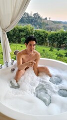 Handsome Man Relaxing in a Bubble Bath at a Chiang Mai Resort in his Honeymoon trip