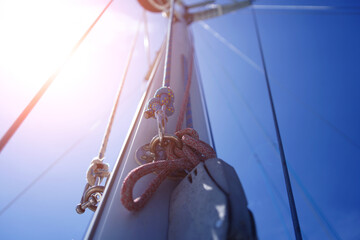 Tall sturdy mast of a sailboat stands out vividly against the bright blue sky.