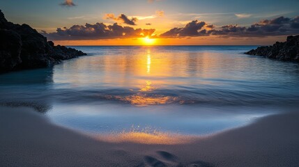 Fototapeta premium Golden sunrise reflecting on tranquil cove waters and sandy beach 