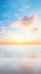 Obraz premium A beautiful sunset over the ocean with a few clouds in the sky