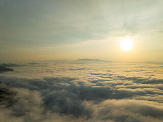 Drone aerial view of landscape fog over mountains in sunrise sky,High angle view over countryside...