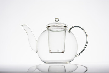 Teekanne aus Glas vor hellem Hintergrund mit Deckel, leer, Silhouette, minimalistisch