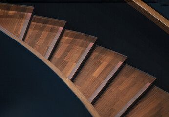 Layered wood spiral stairs with railings handle grip interior. View of Geometric shape of wooden...