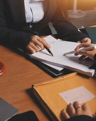 Attractive young lawyer in office Business woman and lawyers discussing contract papers with brass scale on wooden desk in office. Law, legal services, advice, Justice and real estate concept.