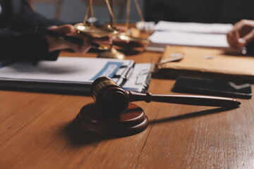 Attractive young lawyer in office Business woman and lawyers discussing contract papers with brass scale on wooden desk in office. Law, legal services, advice, Justice and real estate concept.