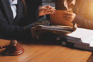 Attractive young lawyer in office Business woman and lawyers discussing contract papers with brass scale on wooden desk in office. Law, legal services, advice, Justice and real estate concept.