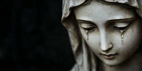 Obraz premium a statue depicting Mary. The statue of Mary presents a deep sorrow, her downcast eyes glistening with tears, and the crystalline teardrops sliding down her cheeks. black bakcground