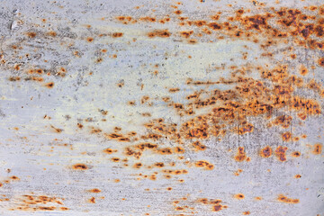 Peeling paint texture reveals rust and rot on the surface of a metal pipe