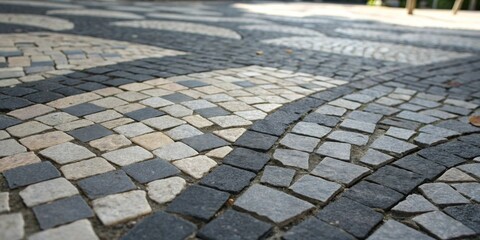 Fototapeta premium A close-up view of a cobblestone path with varying shades of gray and beige stones, creating a unique and intricate pattern.