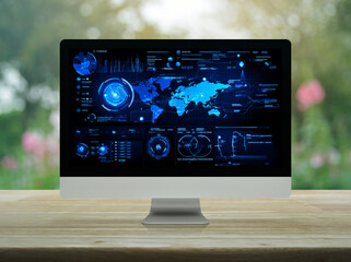 Computer with digital world map with data charts and stats screen on wooden table over blur pink flower and tree in park, Futuristic user interface technology online concept