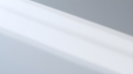 Diagonal light beams creating abstract shadow pattern on white wall