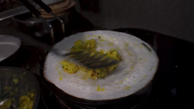 South Indian Dosa, A Crispy fermented rice-lentil crepe with spicy potato filling, dosa preparation in an Indian household.