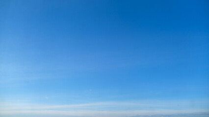 Clear blue sky with light clouds on the horizon, copy space. Natural background with copy space for design and print.