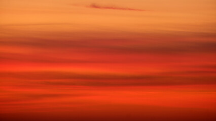 Blurred sunset sky with orange and red gradient clouds. Nature background for design and print