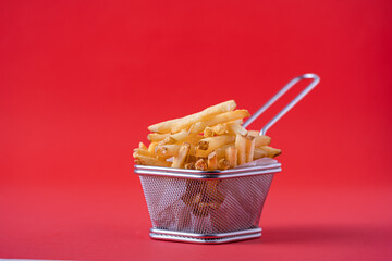 A basket of roasted potatoes . On a red background