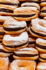 Background of soft brioche buns filled with thick chocolate cream golden dough dusted with powdered sugar creating a sweet and indulgent texture
