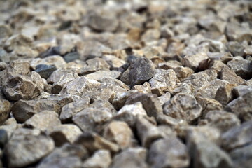 Close-up light beige and white small stones, gravel rugged backg