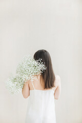 Woman Holding Gypsophila Flowers in White Dress