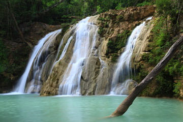 Obraz premium Ko Luang Waterfall is located in Mae Ping National Park. It is a limestone waterfall carved by water from Huay Mae Koh. The stream of water falling down to a large green pond. THAILAND 