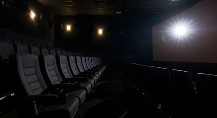Fototapeta premium Side view of empty theater seats with glowing screen