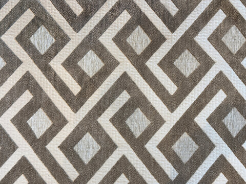 Close up of texture in random geometric diagonal and diamond patterns, with dirt and grunge texture. In brown, white, beige and grey color. for rug, carpet, or fabric seamless background texture.