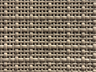 Close up of synthetic plastic rattan in weaving pattern. Close up molded plastic basket in brown color. Seamless background texture.