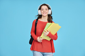 Happy student girl with headphones and notebooks isolated on blue background.