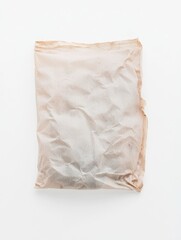 Obraz premium Single Dried Teabag Wrapper on a Clean White Surface