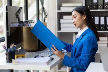 Serious female accountant working with financial documents in office and auditing accounts. Auditor...
