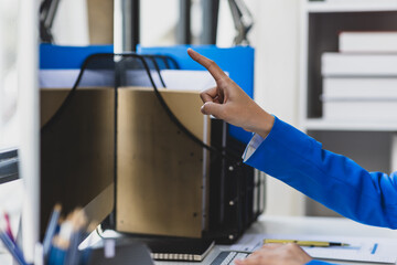 Female hand pointing at computer screen and reading.