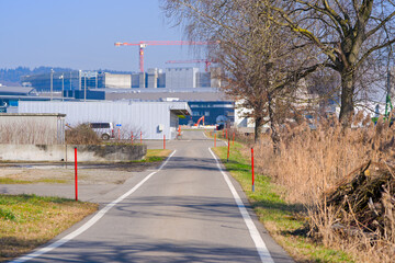 Diminishing perspective of rural road with Swiss Airport Zürich Kloten in the background on a...