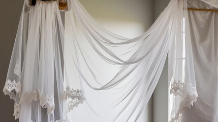 Sheer white curtains with delicate lace trim draped elegantly in softly lit room. Gentle light creates a serene atmosphere, perfect for home decor, weddings, or tranquil spaces.