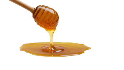 Photo of honey dripping from a wooden dripper isolated on transparent background.png