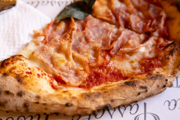 italian neapolitan pizza with ham and basil  