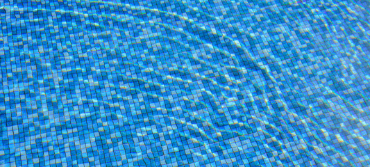 Swimming pool water surface and ripple wave with blue mosaic tiles