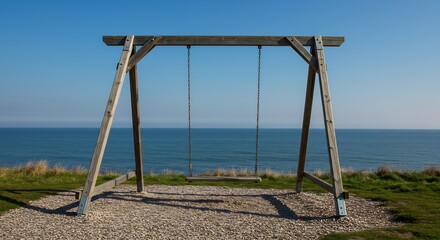 Fototapeta premium Lonely wooden swing set rests peacefully overlooking calm ocean under bright sunlight. AI Generated