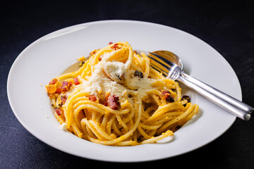 close up of spaghetti carbonara in white bowl