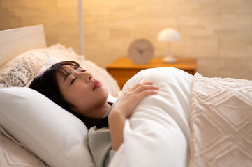 ベッドで眠る日本人女性