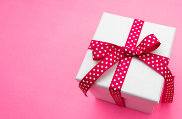Gift box white, red ribbon bow with dots. Christmas present
