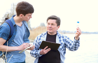 Ecologist working analysis of water pollution. Eco volunteers. Teacher and student conduct audit...